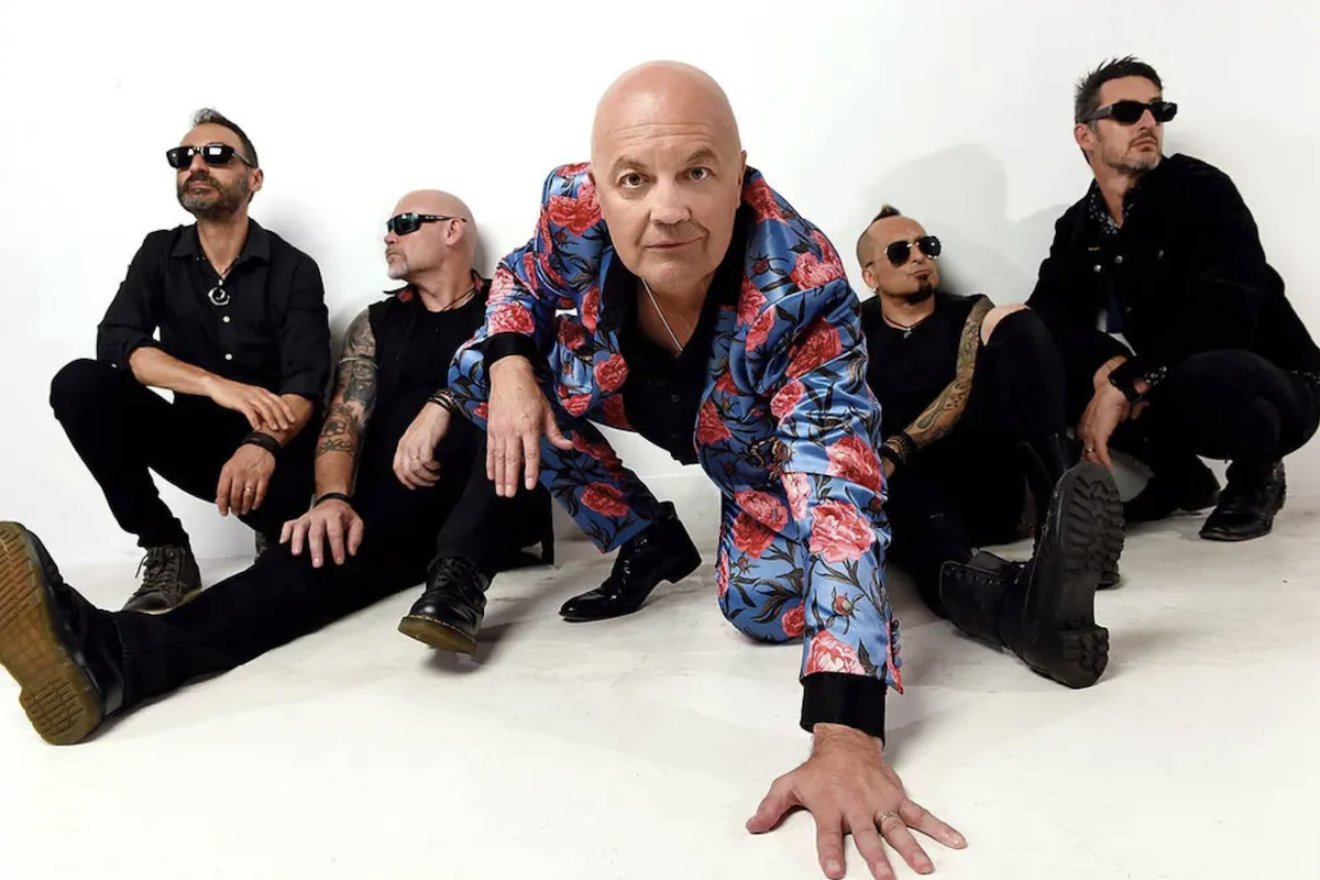 Australian rock band Chocolate Starfish posing together on a white background with frontman Adam Thompson in a floral suit.